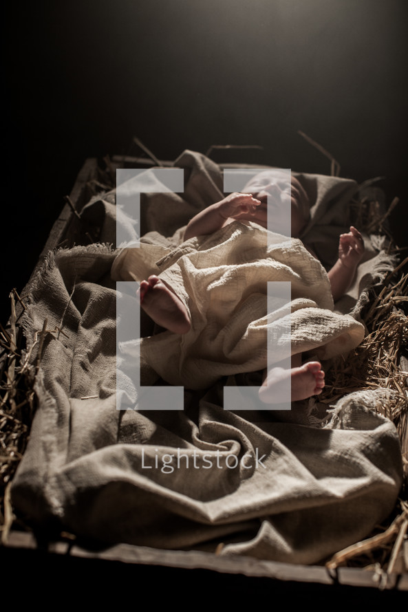 baby Jesus in a manger under glowing light 