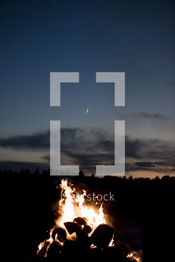 crescent moon over a campfire 
