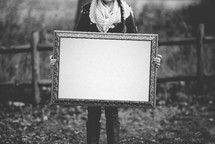 woman holding a blank canvas 