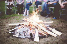 people sitting around a fire pit 