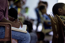 a man reading a Bible during a worship service 