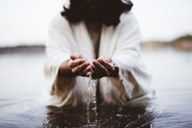 Jesus with cupped hands standing in water 