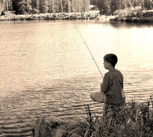boy fishing on the shore of a lake