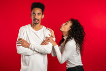 Cute african young woman begging her boyfriend or husband about something over red background