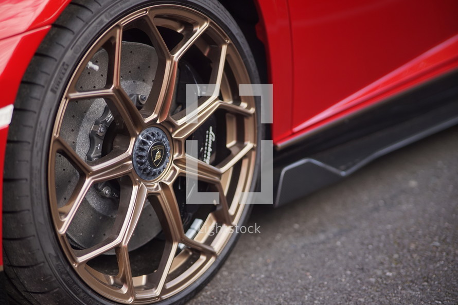 Gold rims on fancy red car