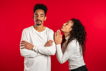 Cute african young woman begging her boyfriend or husband about something over red background