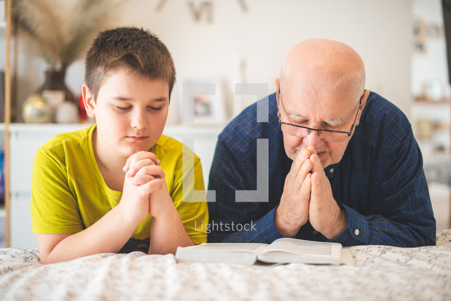 grandfather and grandson praying together 