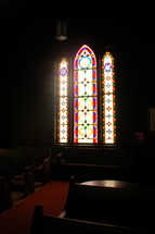 Light coming through stained glass windows in a church.