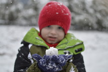 boy child holding a snow ball 