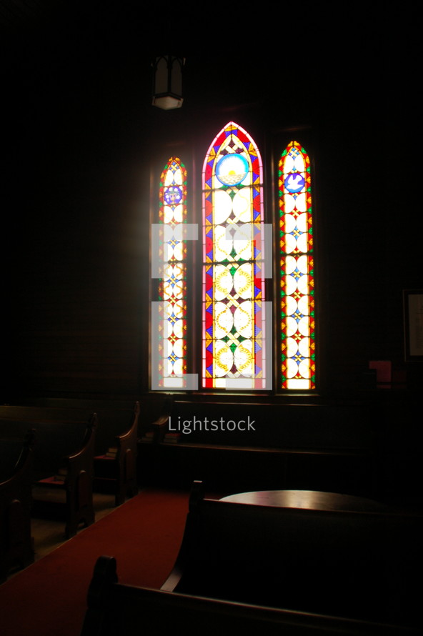 Light coming through stained glass windows in a church.