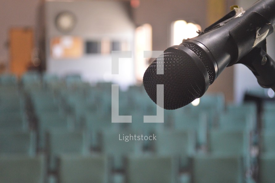 microphone and rows of empty seats in a church 