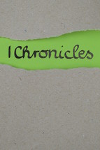 torn open kraft paper over green paper with the name of the 1 book of Chronicles