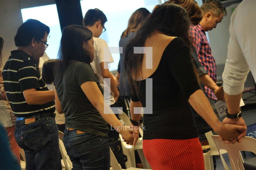 holding hands in prayer during a worship service 