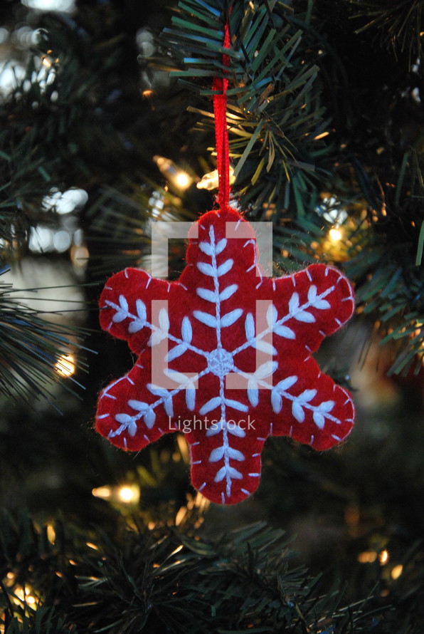 red snowflake ornament on a Christmas tree 