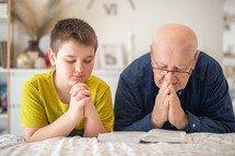 father and teen son praying together 