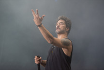 Man gesturing in a concert with a microphone