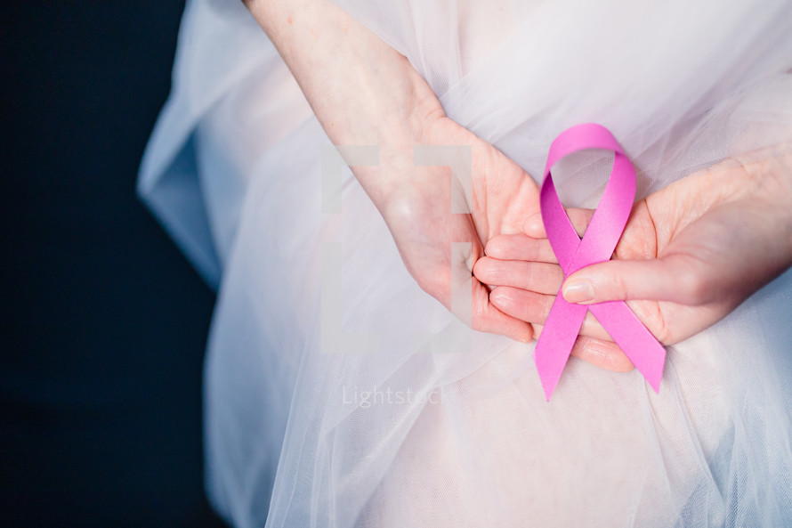 Woman holding pink breast cancer ribbon