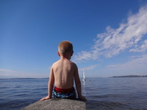 boy watching sailboats 