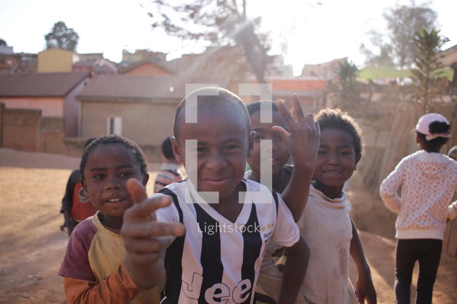 Joyful group of black children in front of homes