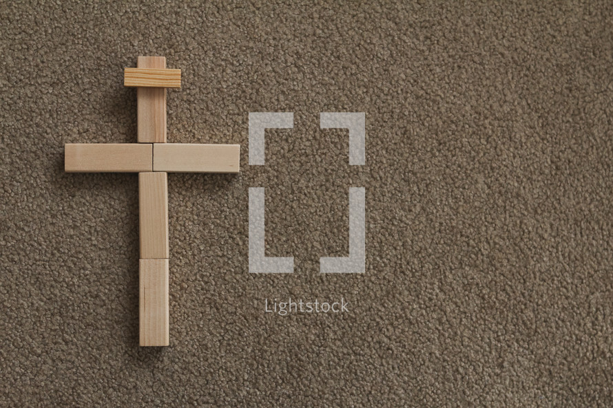 cross made of wooden blocks on carpet 