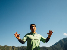 Man standing outside in front of mountains.