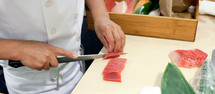 Hand was sliced fish to make sushi in chelsea market, New York