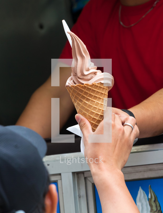 Selling ice cream with typical ice cream truck, detail of the hand of the customer while taking the ice cream