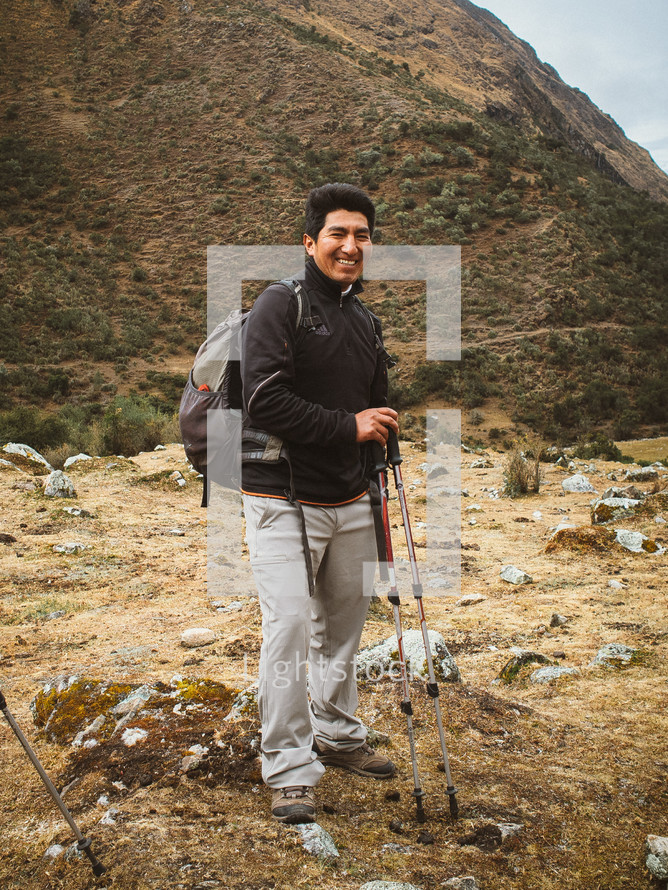 man backpacking with hiking sticks 