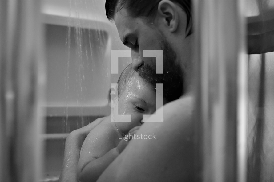 a father holding a baby in the shower 