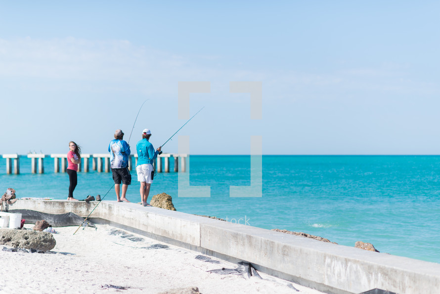 men fishing on a shore 