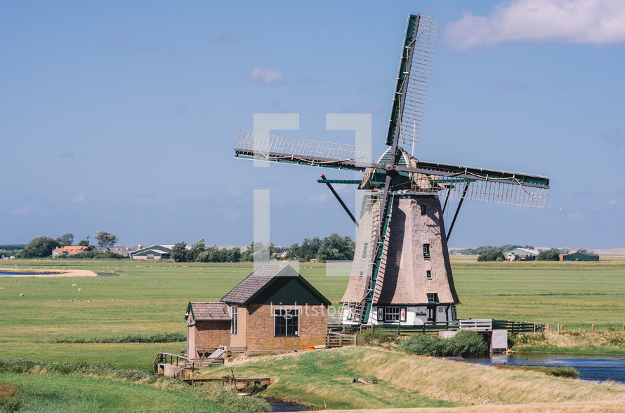Old Dutch windmill and green fields