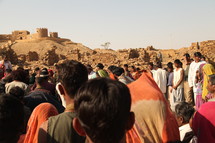 gathering of people in front of an old fortress 