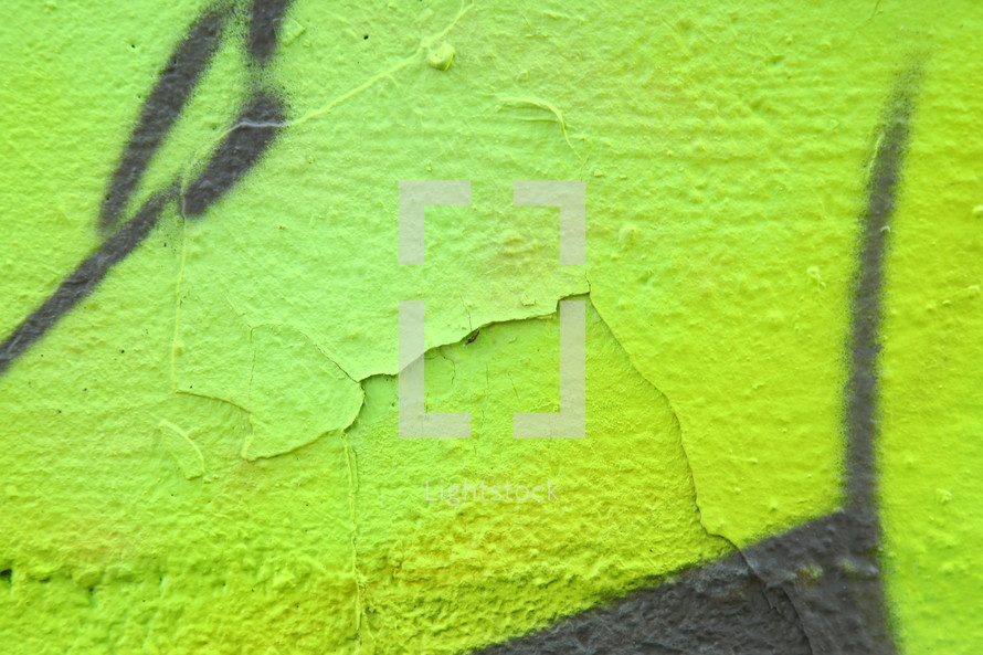 peeling paint on a graffiti covered wall