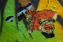 peeling paint on a graffiti covered wall 