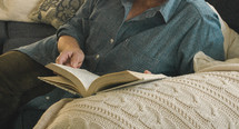 woman reading a Bible on a couch 