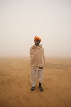 man standing in a desert during a dust storm