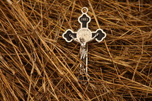 silver crucifix necklace on straw