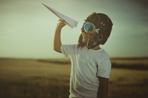 a child flying a paper airplane 