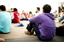 Teens sitting on the floor during a worship study.
