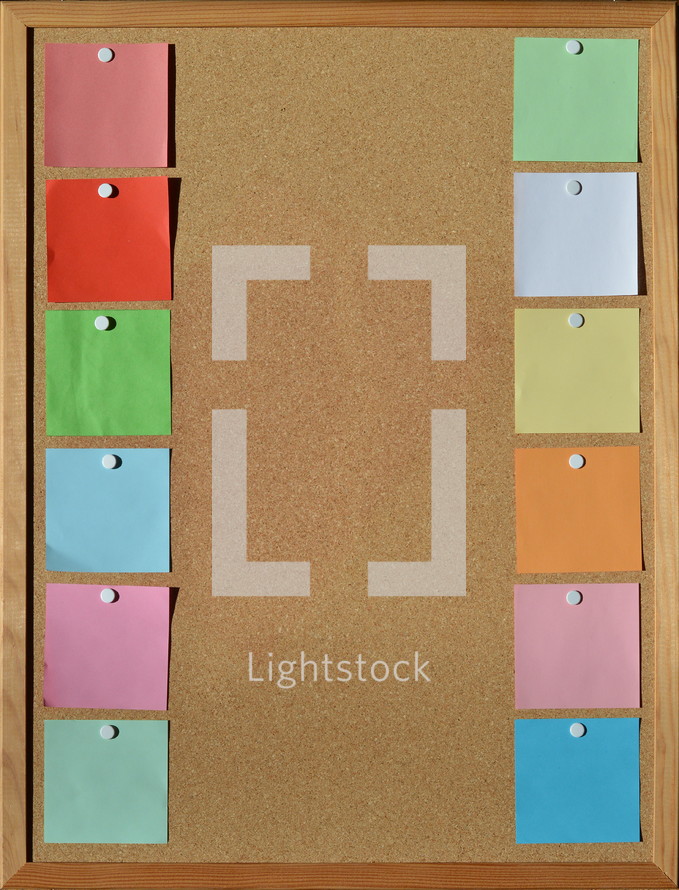 blank sticky notes pinned to a cork board 