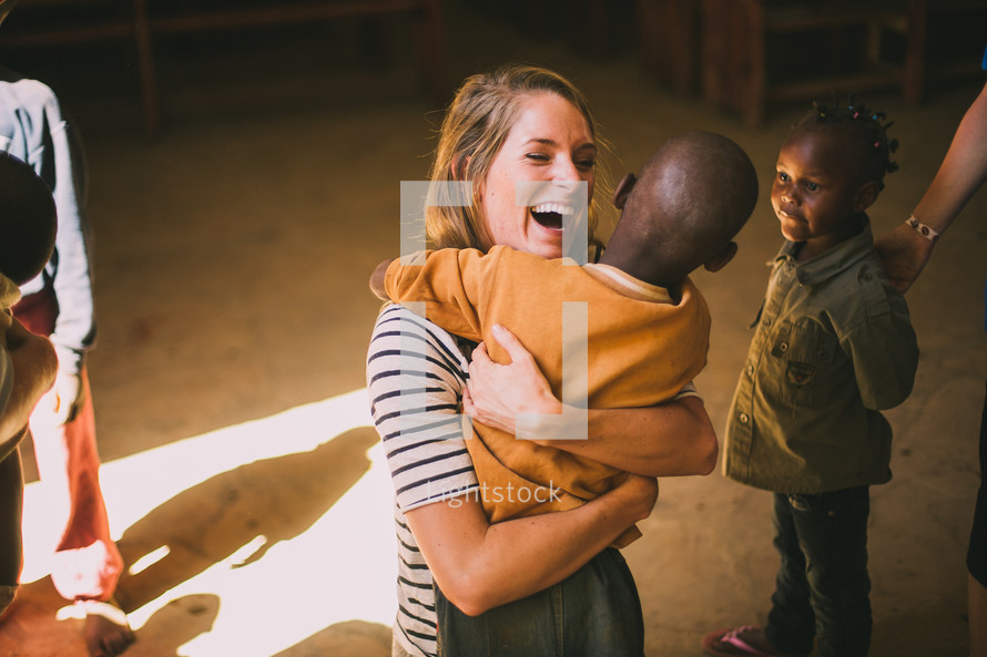 missionary hugging a boy child 