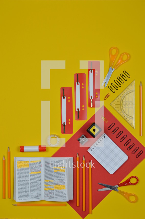 office supplies on red and yellow and Bible 