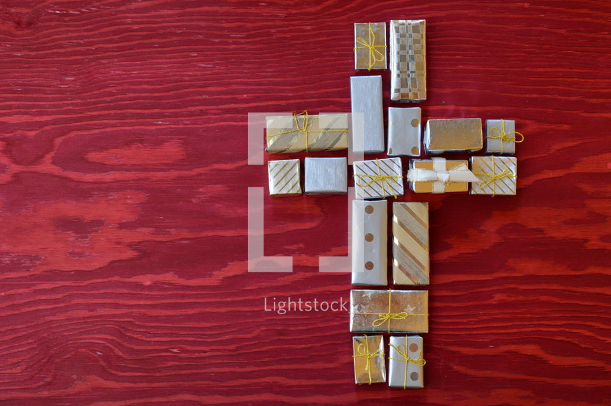 many little presents shaping a cross on red wooden background