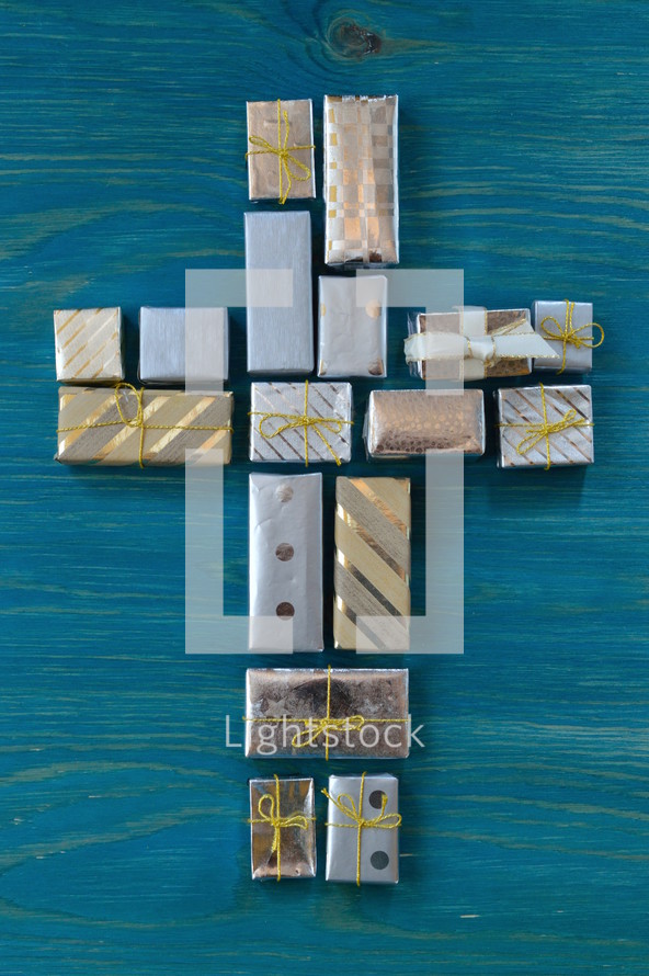many little presents shaping a cross on teal wooden background