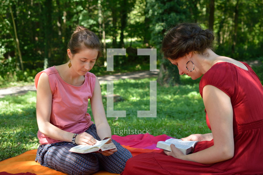 women reading Bibles on a blanket 
