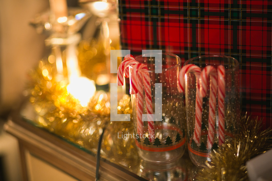 Candy canes in Christmas glasses on a holiday table.