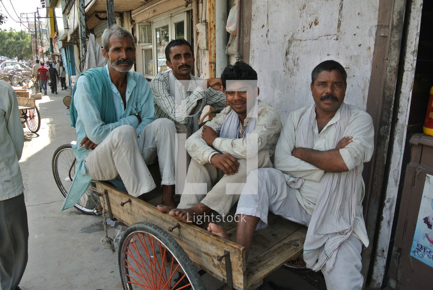 men sitting in a pedicab wagon