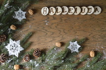 star ornaments, pine cones, snow, pine boughs and the word HALLELUJA on wooden slices