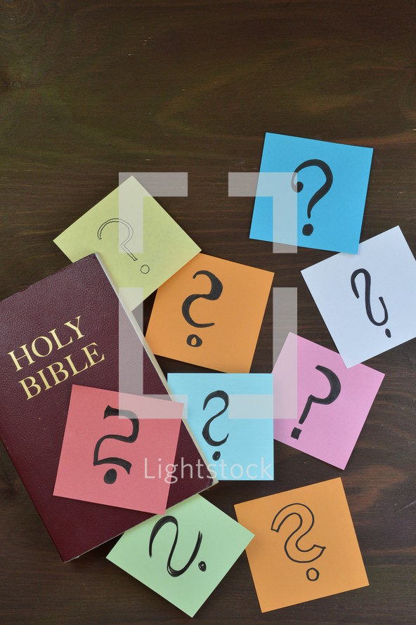 Holy Bible and question marks on sticky notes 