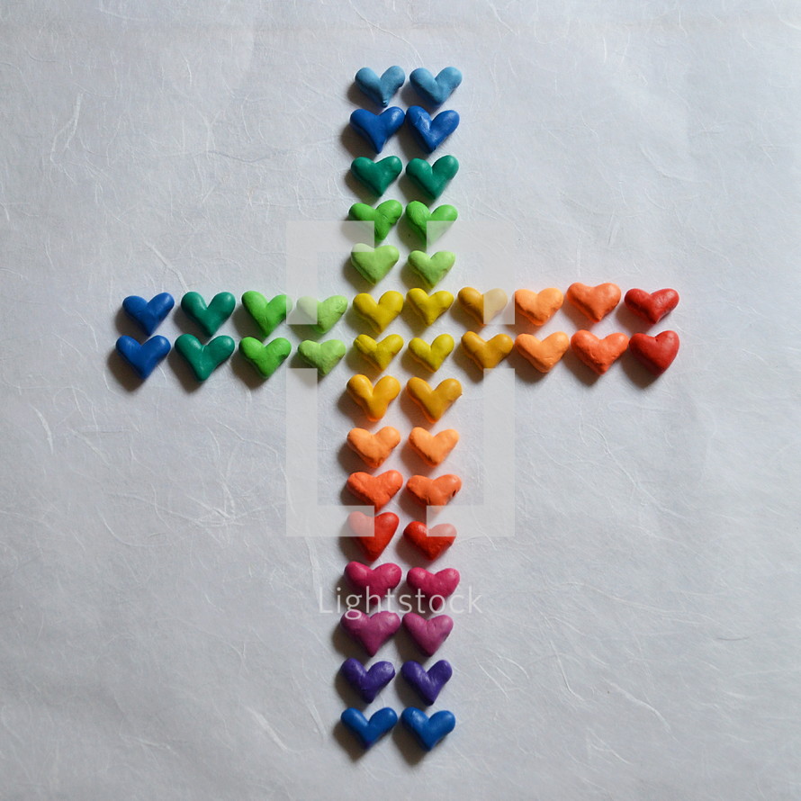 Many small, different colored hearts in the shape of a cross.